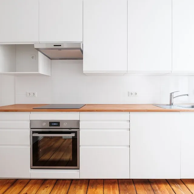 En Da Desings, estamos listos para escuchar tus ideas y transformar tus espacios. Llámanos, envíanos un correo o completa el formulario y nos pondremos en contacto contigo. cocina de suelo madera y muebles blancos